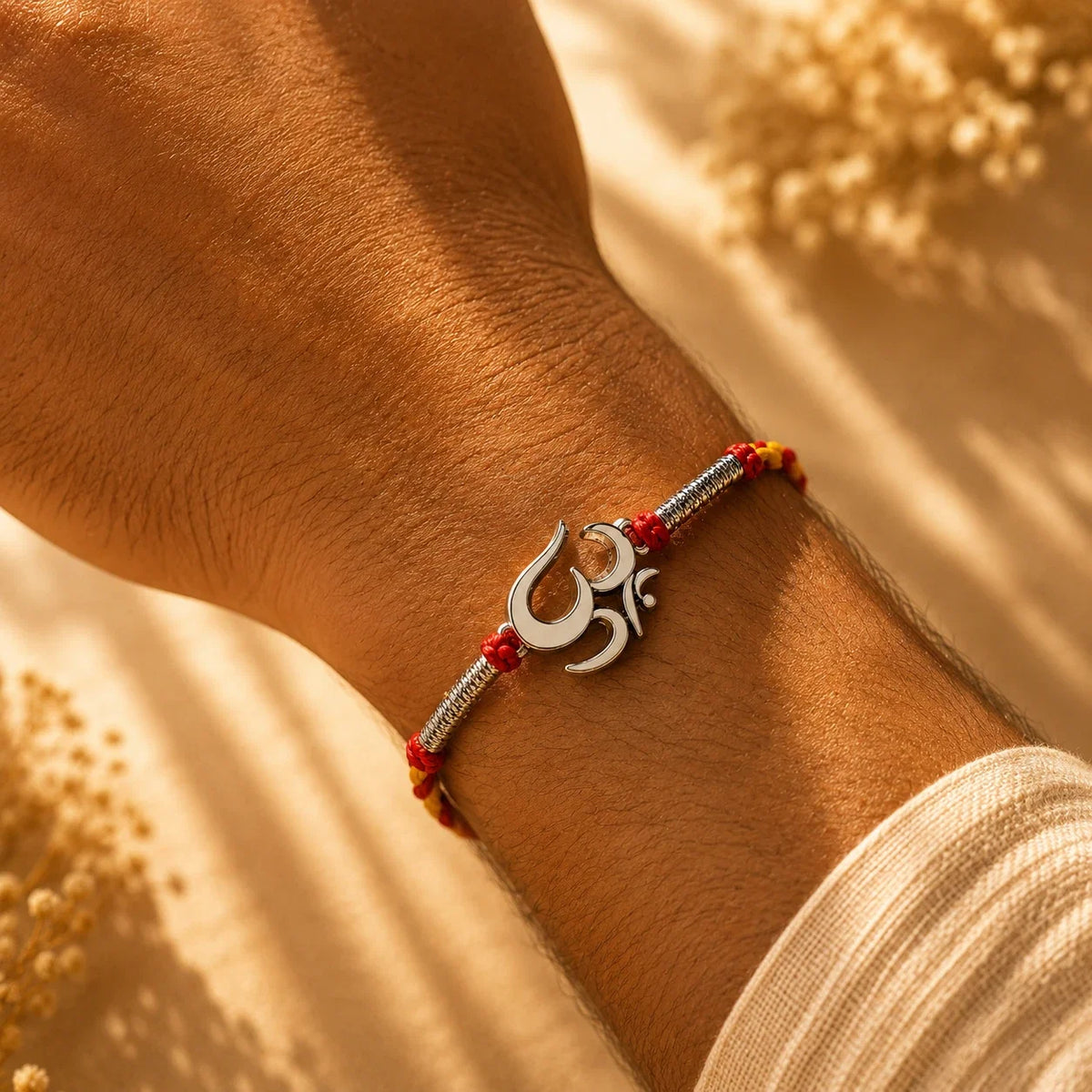 925 silver Big Om rakhi with an Om motif on a red and gold braided thread