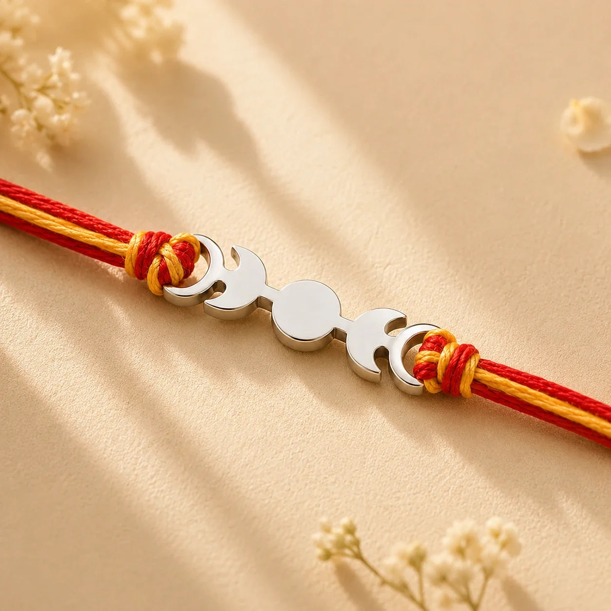 925 silver designer rakhi on a red and gold braided thread