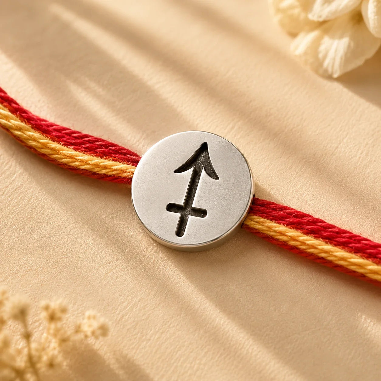 925 silver Sagittarius zodiac rakhi on a red and gold braided thread