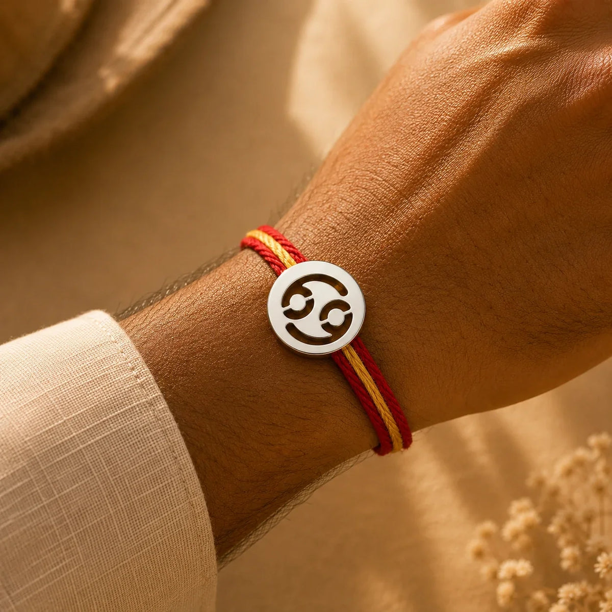 925 silver Cancer zodiac rakhi on a red and gold braided thread