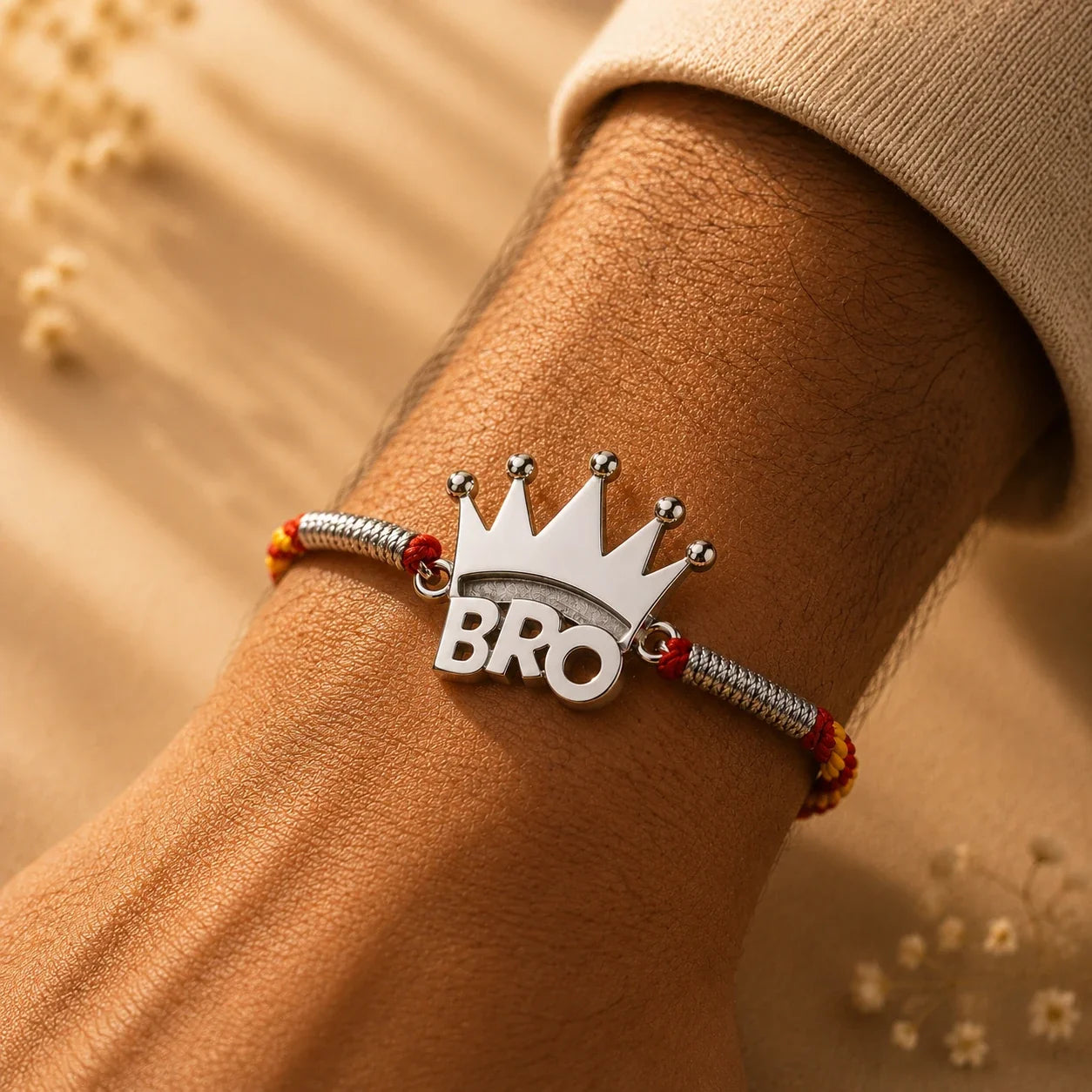 925 silver Crown Bro rakhi with a crowned BRO charm on a red and gold braided thread