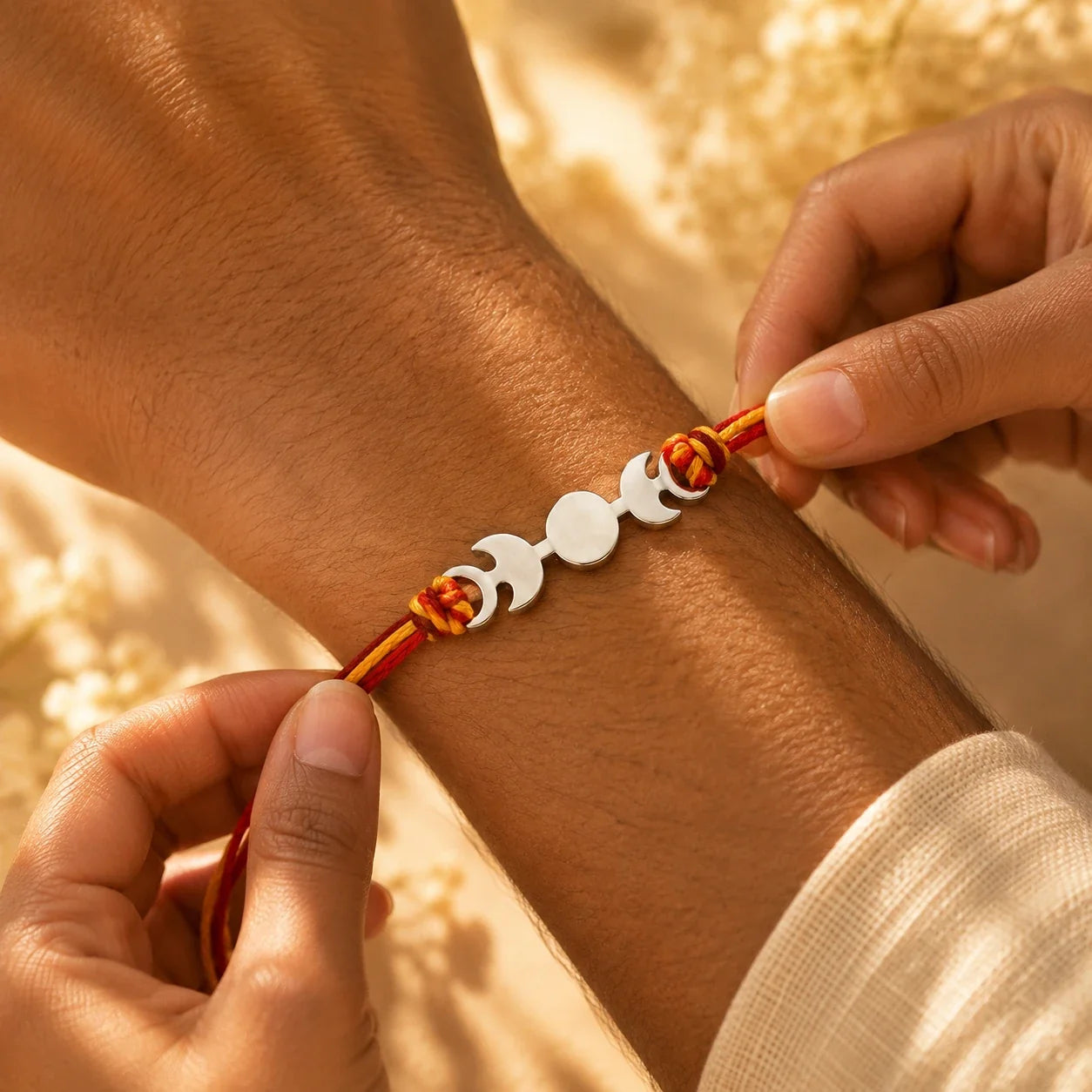 925 silver designer rakhi on a red and gold braided thread