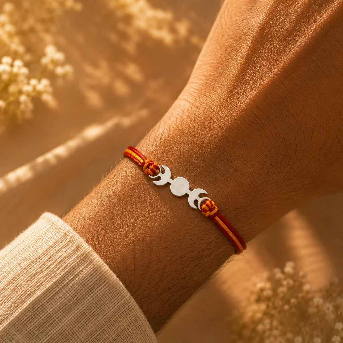 925 silver designer rakhi on a red and gold braided thread