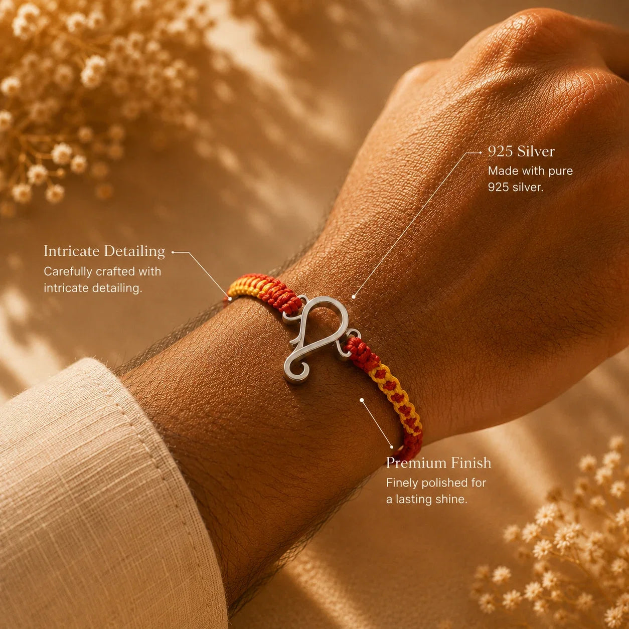 925 silver Ganesha rakhi with a Ganesha motif on a red and gold braided thread