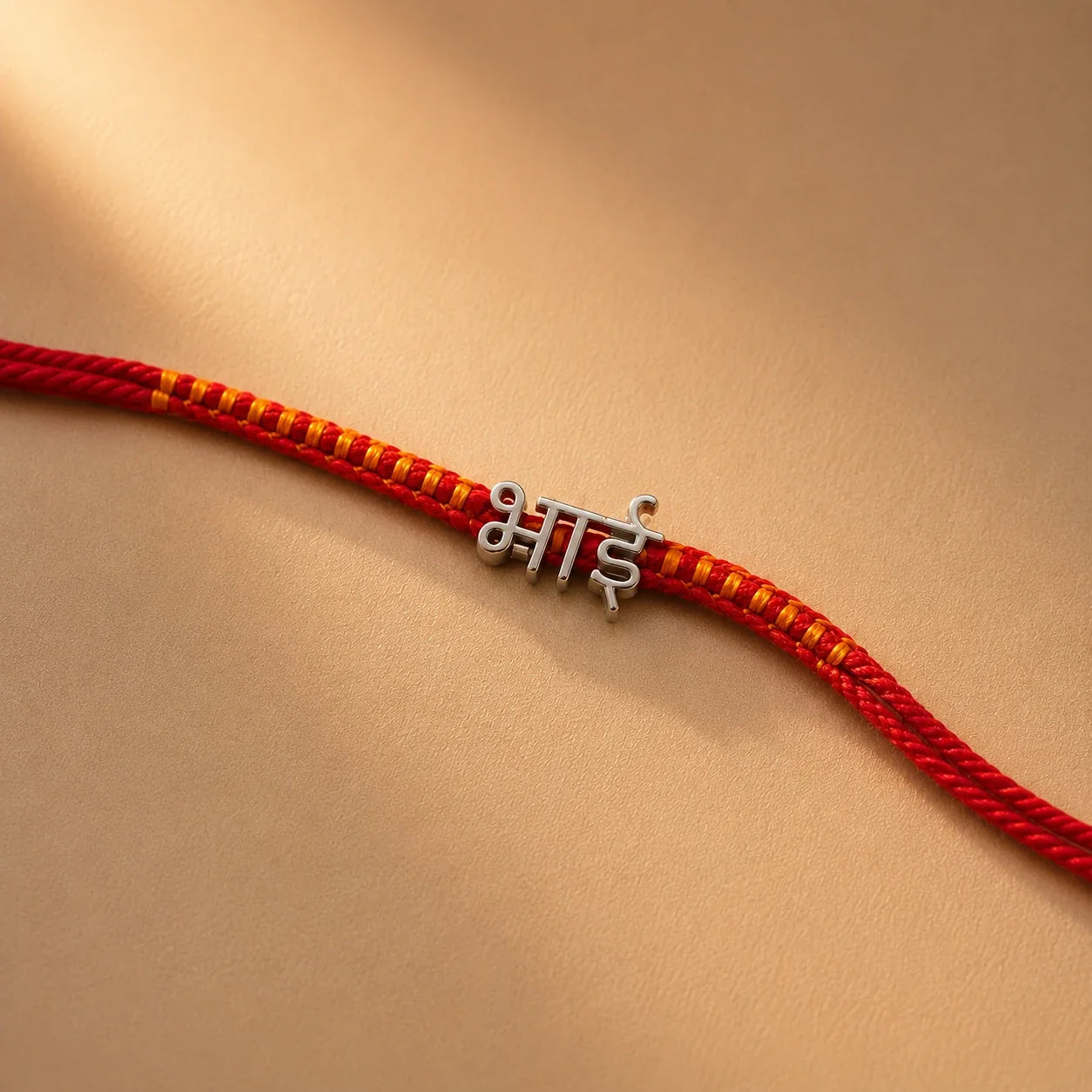 925 silver Hindi Bhai rakhi with भाई engraved in Hindi script on a red braided thread