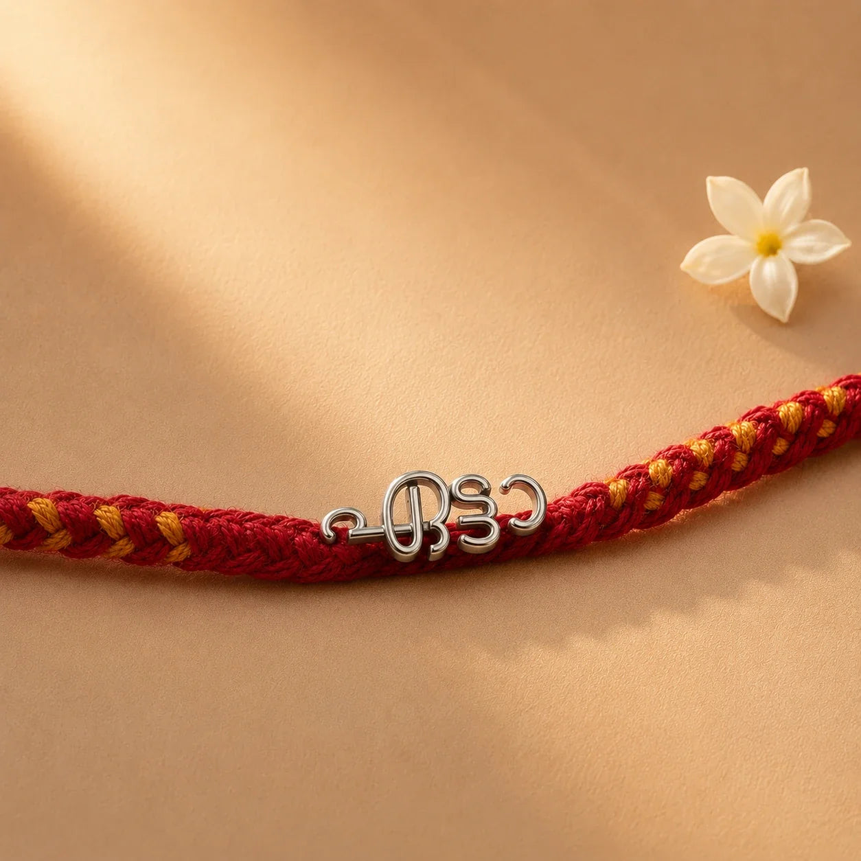 925 silver Malayalam Etta rakhi with ഏട്ടൻ engraved in Malayalam script on a red braided thread