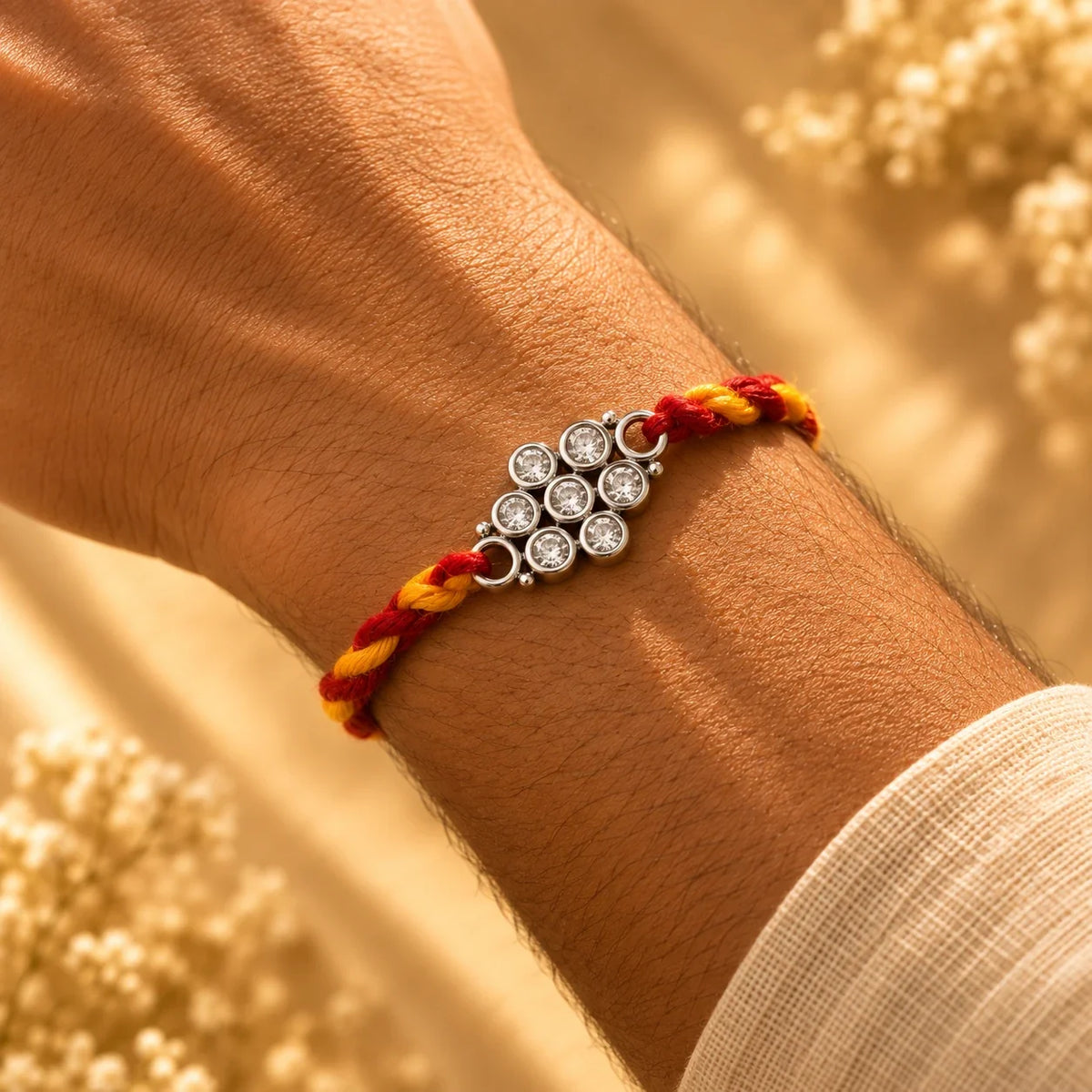 925 silver small polki flower rakhi on a red and gold braided thread