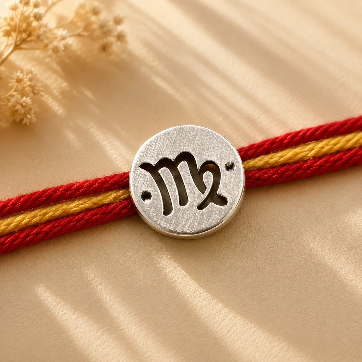 925 silver Virgo zodiac rakhi on a red and gold braided thread